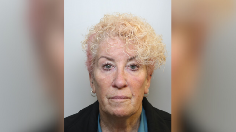 Mugshot of blonde hair wearing hoop earrings.