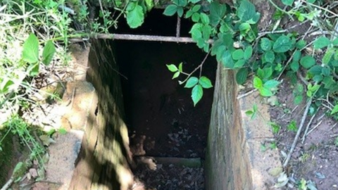 A brick-lined entrance leading down to the underground bunker.