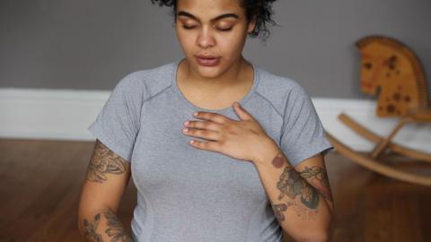 Woman breathing deeply while holding baby bump.