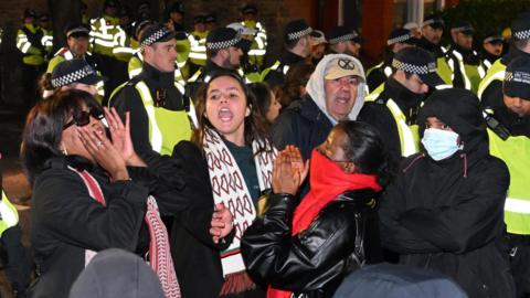 Demonstrators protest next to police officers near a Kurdish community centre after a counter terrorism investigation into suspected activity linked to the banned Kurdistan Workers Party, known as the PKK, in London.