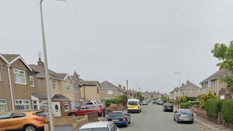 Black Butts Lane in Walney. The street has houses either side of the road, with some cars parked on drives and come on the street.