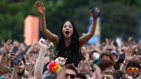 A woman in a black top is helad above the crowds at TRNSMT Festival 2024