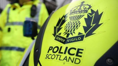 A yellow police vehicle with the words POLICE SCOTLAND in bold.