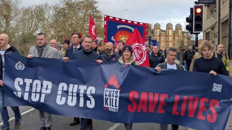 FBU members holding a banner whilst marching through Oxford.