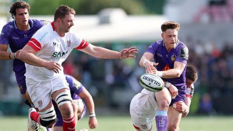 Stephen Varney (right) throws the ball to pass under a tackle