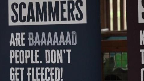 Scammer poster - it says Scammer are baaaad people. Don't be fleeced! It was designed by students. White text on a black background.