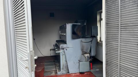 Photo of a silver and grey substation with black, smoke damaged walls.