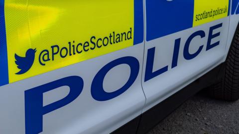 The side of a police car with Police and Police Scotland written on it