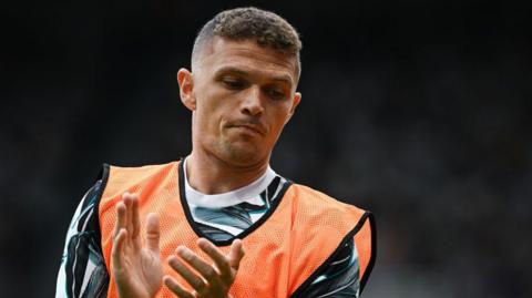 Kieran Trippier claps while wearing a training bib