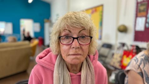 Gillian Hearn wearing glasses and a pink jumper