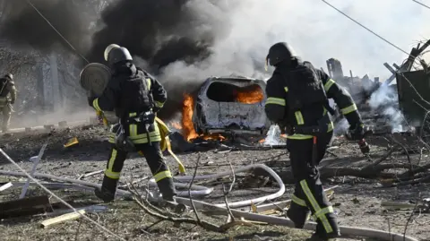  Ukrainian firefighters work at the site of a strike in the city of Kramatorsk