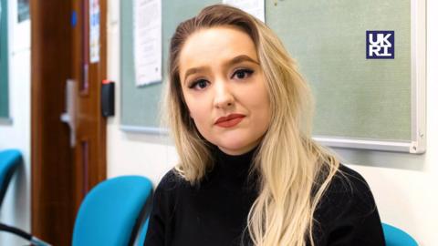 Presenter Ellie Colton in a hospital corridor