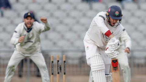 The bails are off as Luke Wells is bowled with a Derbyshire fielder celebrating in the background