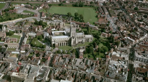 Drone shot showing aerial view of Gloucester Cathedral and surrounding streets.