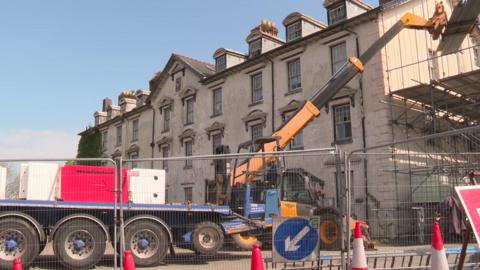 Peiriannau trwm a sgaffaldiau yn amgylchynu'r Corbett Arms