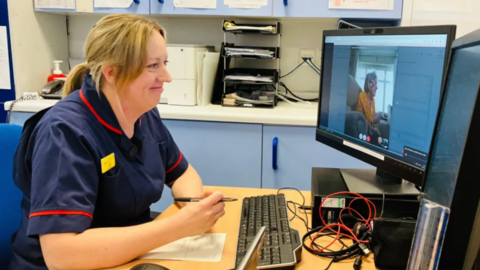 A nurse looking at a monitor