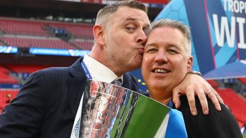 Peterborough chairman Darragh MacAnthony kisses manager Darren Ferguson after their win over Wycombe in the 2024 EFL Trophy final