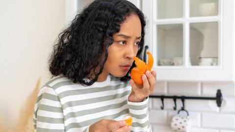 Girl smelling an orange