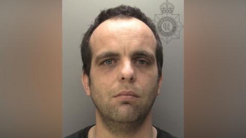 Police mug shot of Daniel Tranmer. He has dark hair and is looking directly at the camera.