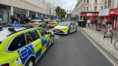 Four police cars and a taped off road at Western Road in Brighton 