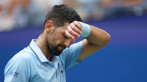 Novak Djokovic wipes his brow at the 2025 US Open
