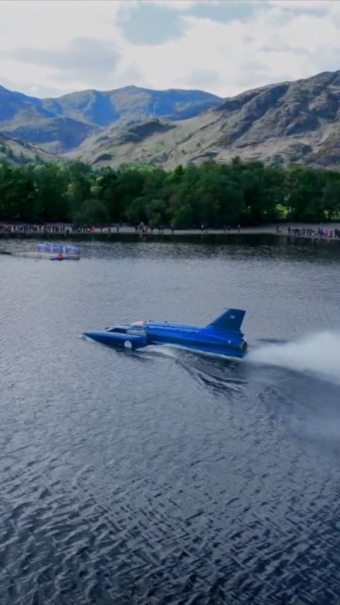 The Bluebird hydroplane on Coniston water. There are peaks in the background.