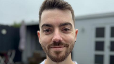 Man with beard smiling into the camera