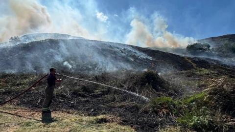 Firefighter with a hose tackling a hotspot