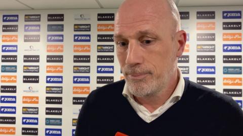 Philippe Clement wearing a white shirt and black v-neck jumpter