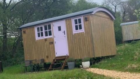 Hut on two wheels at a slanted angle.