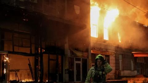 A firefighter works at the site of a Russian drone attack, amid Russia's attack on Ukraine, in Kyiv,