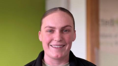 Julie-Anne Hosick. She has brown hair tied back wearing a black zip up fleece with Connected Health written on it and a cream t-shirt underneath. She is smiling at the camera.