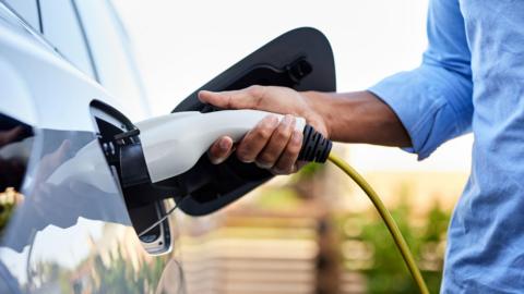 Close up of person charging electric car