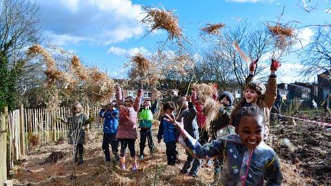 Mulching being carried out at by excited children at a school tiny forest site