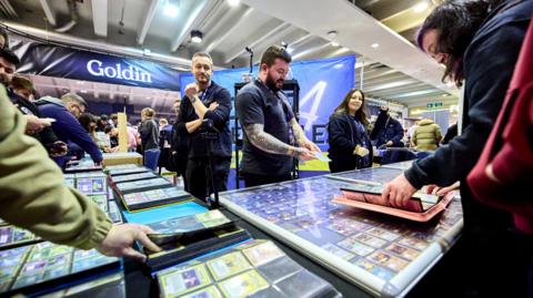 Collectors look through collectable cards at a collectors' fair.