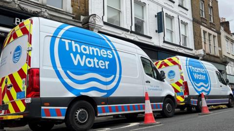 Two Thames Water vans parked on a high street