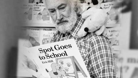 Author Eric Hill reading a book entitled 'Spot Goes to School'