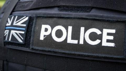 Rear view of a police jacket with the union flag depicted in white, black and blue.