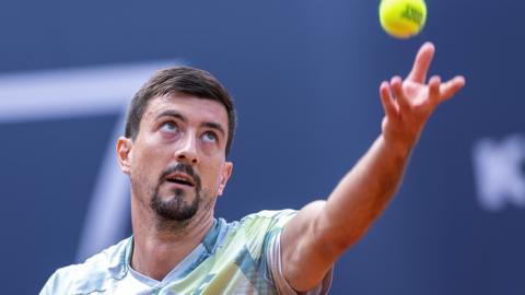 Sebastian Ofner throws the ball to serve