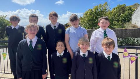 school children smiling at the camera.
