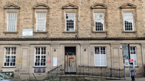 The Post Office branch in Kendal is a multi-storey white stone building with large white windows. The words: "Post Office" are engraved into the stone above the door.