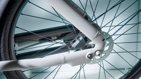 The wheel of an e-bike, with a white frame going to its centre.