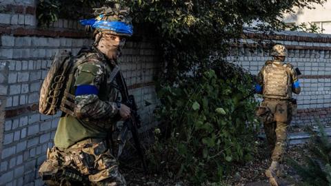 Ukrainian soldiers walk in the Ukrainian controlled city of Sudzha on August 18th 2024, in Kursk Region, Russia. Ukrainian forces operating in Russia's Kursk Region have destroyed a second key bridge, Commander of Ukrainian Air Force said, as they attempt to push further into Russia.