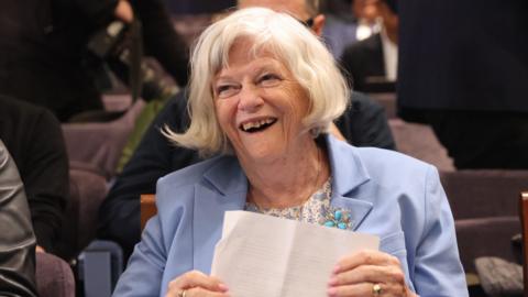 Ann Widdecombe in a blue blazer laughing.