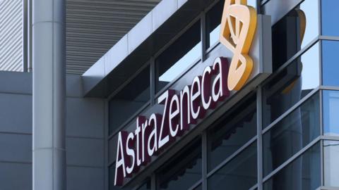 A 3D AstraZeneca sign fixed to a modern glass building.