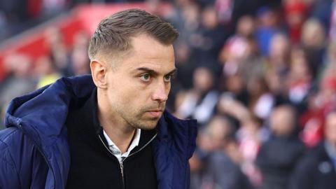 Southampton manager Tonda Eckert in blue coat and black zip-up top