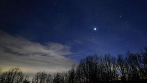 A photograph shows bright planets in an evening sky
