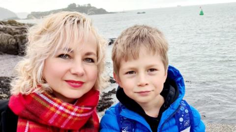 Svitlana Santos pictured with her son in front of the sea. 