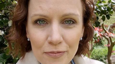 Presenter Alex Humphrey's in park standing in front of tree