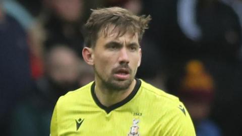 Sam Walker in a yellow Bradford City goalkeeper jersey during a match